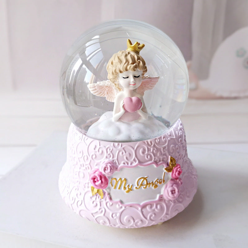 Snow globe crystal ball music box glowing among celestial desk accessories