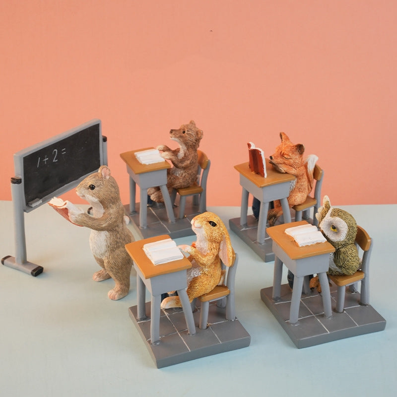 Miniature classroom scene with cute animal figurines, bookshelf, desks, and chalkboard
